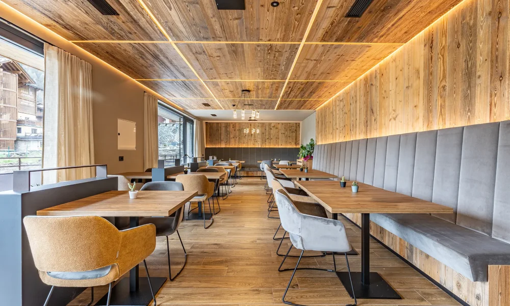 Sala da pranzo moderna con arredamento in legno e sedie imbottite.