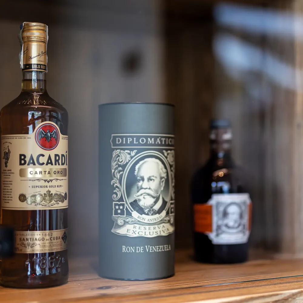 Bottiglie di rum su uno scaffale di legno.